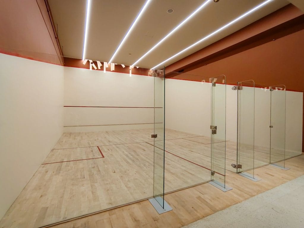 Modern Squash Court with Glass Walls and Wooden Flooring